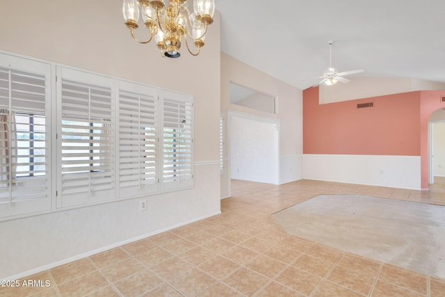 tiled empty room featuring high vaulted ceiling, ceiling fan, visible vents, and arched walkways