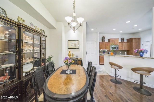 dining area featuring dark wood-style flooring, a chandelier, and recessed lighting
