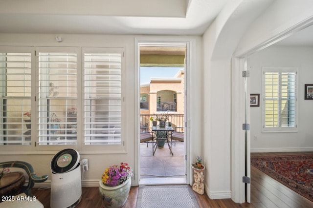 doorway to outside with baseboards and wood finished floors