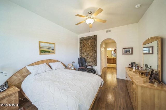 bedroom with ceiling fan, arched walkways, baseboards, wood finished floors, and visible vents