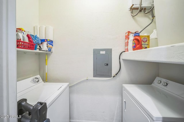 clothes washing area with electric panel, laundry area, and washer and dryer