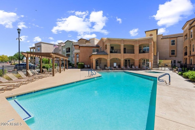 pool featuring a patio area, fence, a pergola, and a residential view