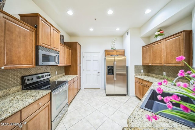kitchen featuring backsplash, visible vents, a sink, light tile patterned floors, and stainless steel appliances