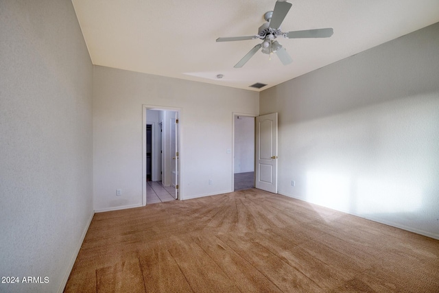 unfurnished bedroom featuring ensuite bathroom, ceiling fan, and light colored carpet