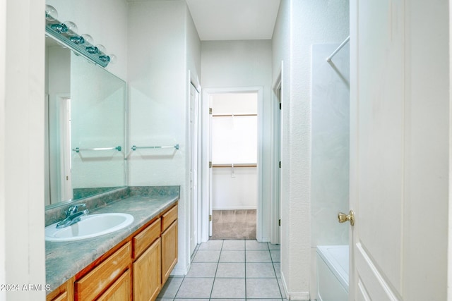 bathroom featuring tile patterned flooring, vanity, and a tub