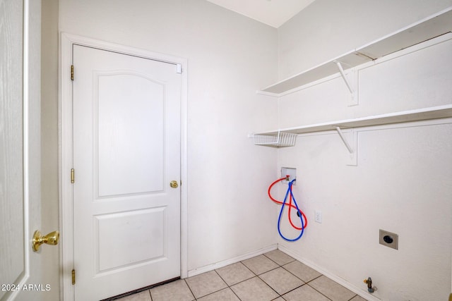 clothes washing area featuring hookup for a washing machine, light tile patterned floors, gas dryer hookup, and electric dryer hookup