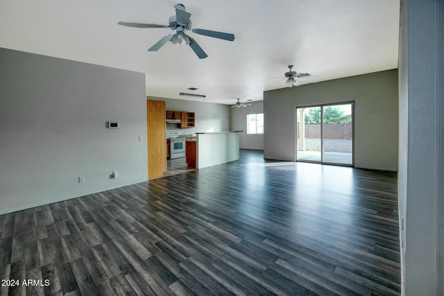 unfurnished living room with dark hardwood / wood-style floors and ceiling fan