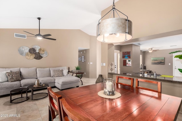 dining space featuring light tile patterned floors, visible vents, high vaulted ceiling, and ceiling fan