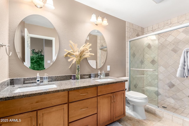 bathroom with a shower stall, toilet, and a sink