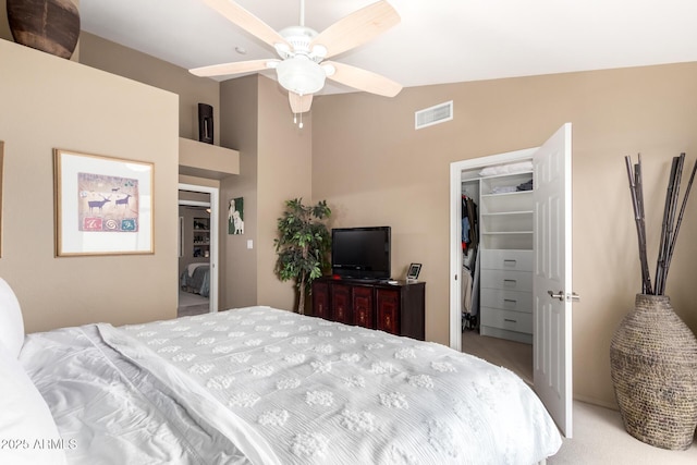 bedroom with lofted ceiling, visible vents, a walk in closet, a closet, and carpet flooring