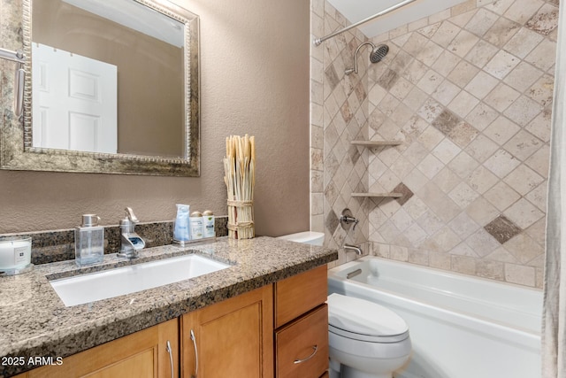 bathroom featuring a textured wall, vanity, shower / tub combination, and toilet