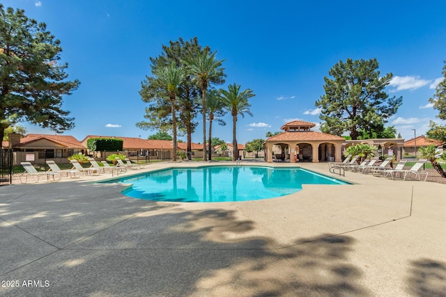 pool with a patio area and fence
