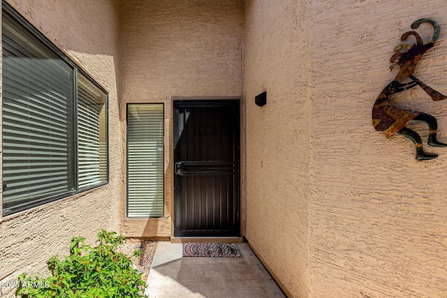 view of exterior entry featuring stucco siding
