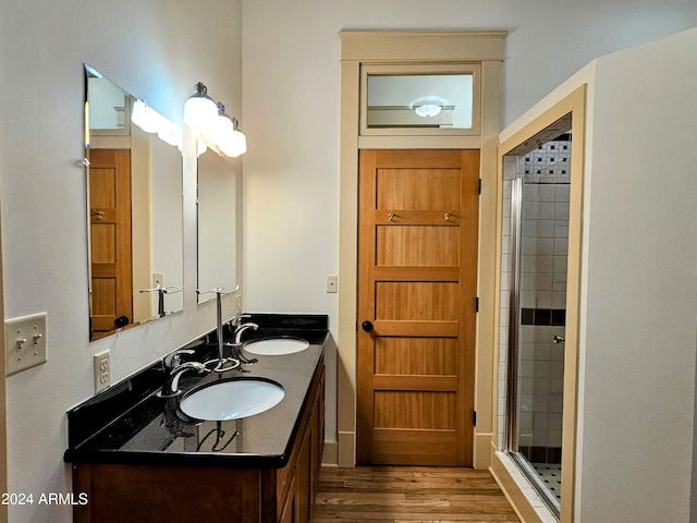 bathroom featuring walk in shower, hardwood / wood-style flooring, and dual bowl vanity