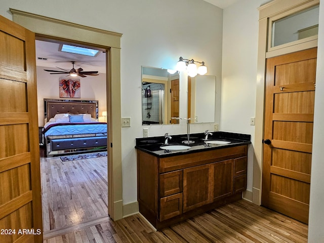 bathroom featuring double sink vanity, hardwood / wood-style floors, and ceiling fan