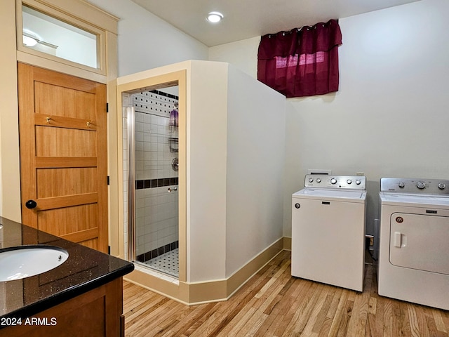 laundry area featuring sink, separate washer and dryer, and light hardwood / wood-style floors