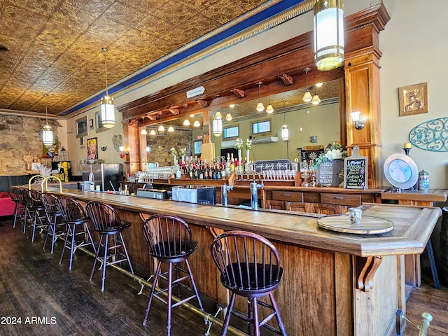 bar featuring pendant lighting, dark hardwood / wood-style floors, crown molding, and stainless steel fridge