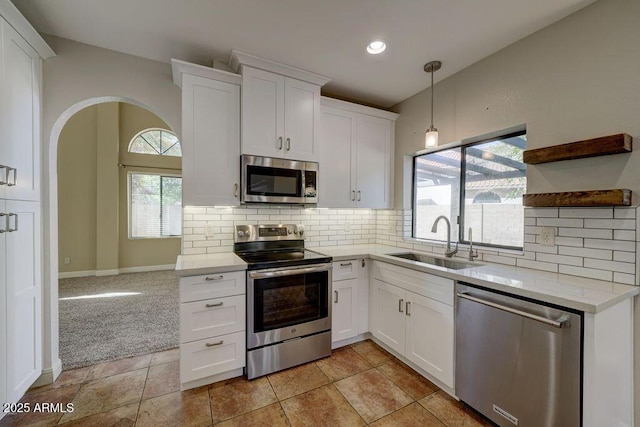 1010 N Osprey Ct, Gilbert, AZ 85234 - kitchen featuring a sink, open shelves, backsplash, white cabinets, and appliances with stainless steel finishes