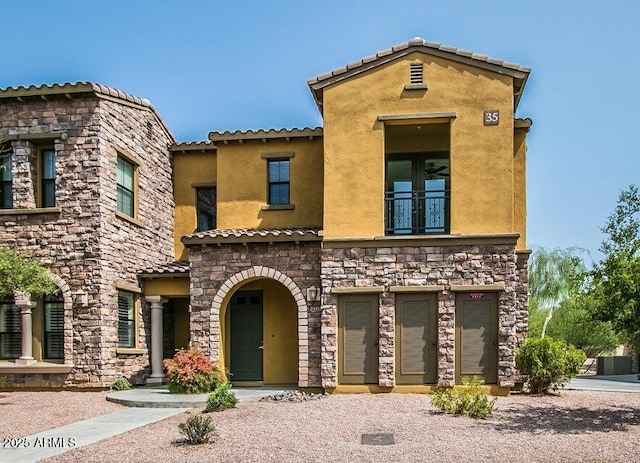 20750 N 87th St Unit 2103, Scottsdale, AZ 85255 - view of front of home featuring stucco siding, a balcony, stone siding, a tile roof, and french doors
