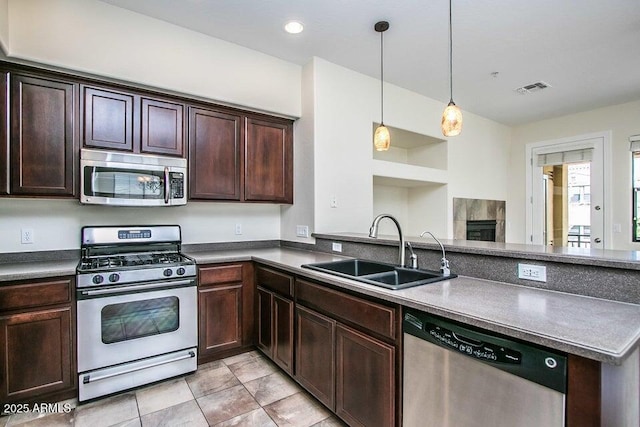 20750 N 87th St Unit 2103, Scottsdale, AZ 85255 - kitchen with stainless steel appliances, a sink, dark brown cabinetry, a peninsula, and dark countertops