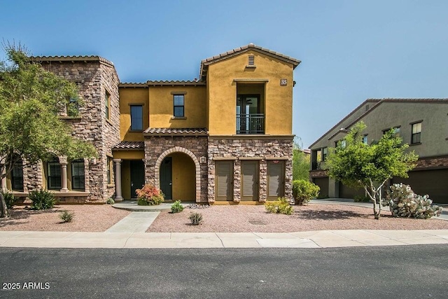 20750 N 87th St Unit 2103, Scottsdale, AZ 85255 - view of front of property with stucco siding, stone siding, a tiled roof, a balcony, and an attached garage