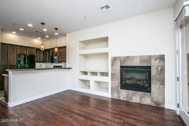 20750 N 87th St Unit 2103, Scottsdale, AZ 85255 - kitchen with black refrigerator with ice dispenser, built in shelves, stainless steel microwave, dark wood finished floors, and recessed lighting
