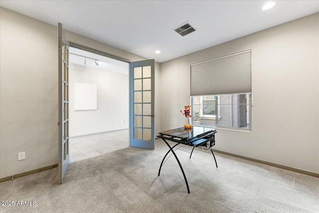 unfurnished office featuring french doors, light colored carpet, and rail lighting