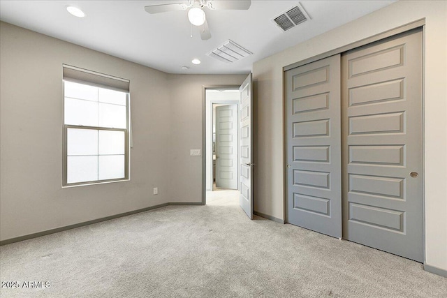 unfurnished bedroom with light carpet, a closet, and ceiling fan