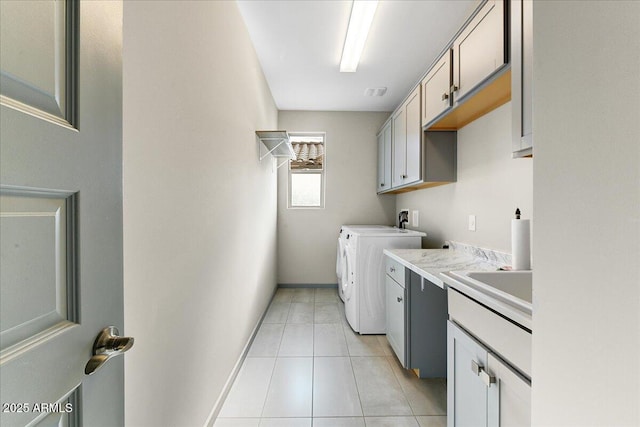 washroom featuring independent washer and dryer, sink, cabinets, and light tile patterned flooring