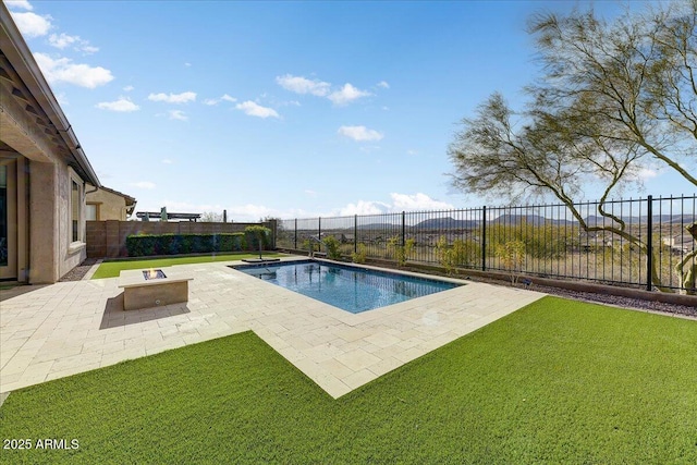 view of pool featuring a patio, a fire pit, and a lawn