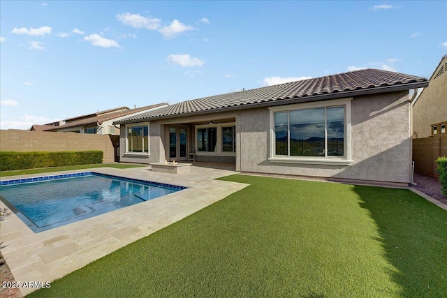 back of house with a yard, a fenced in pool, and a patio area