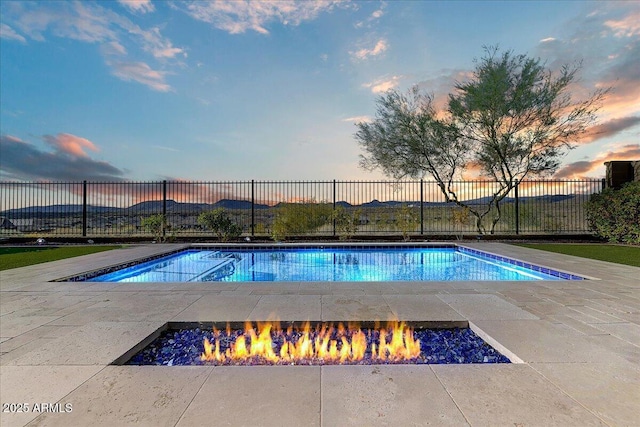 pool at dusk featuring a patio area