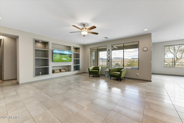 unfurnished room featuring light tile patterned floors, ceiling fan, and built in shelves