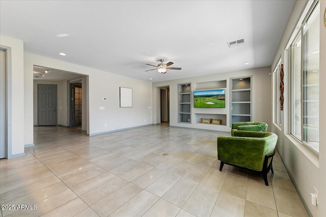 living room with built in shelves, ceiling fan, and light tile patterned flooring