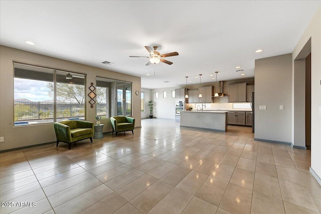 unfurnished living room with light tile patterned flooring and ceiling fan