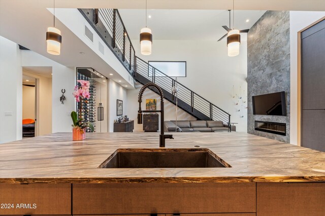 kitchen with hanging light fixtures, sink, and a high end fireplace