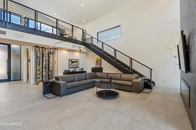 living room featuring a towering ceiling and light tile patterned flooring