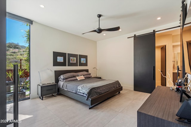 bedroom featuring ceiling fan, access to outside, and a barn door