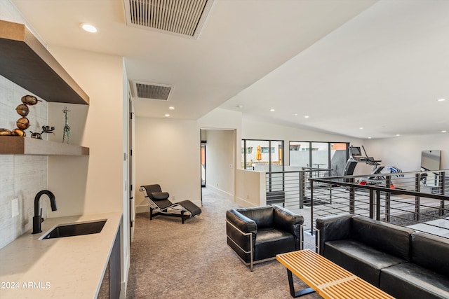 interior space with light carpet, vaulted ceiling, and sink