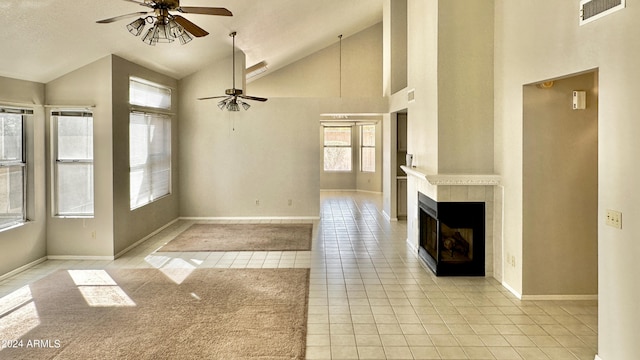 unfurnished living room featuring ceiling fan, high vaulted ceiling, a tile fireplace, and light tile patterned flooring