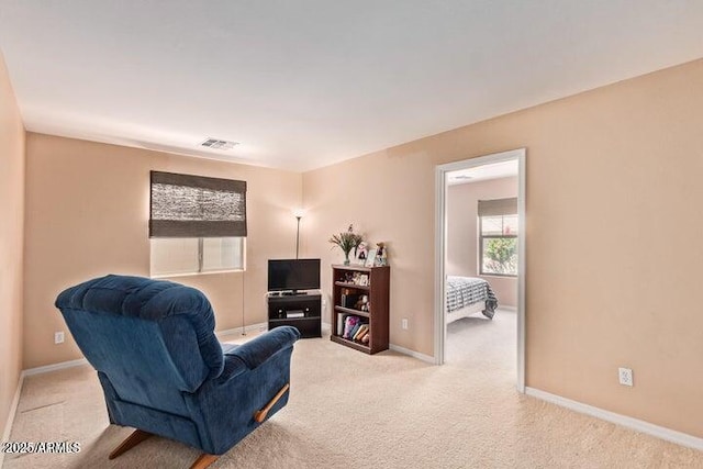 living area featuring light carpet