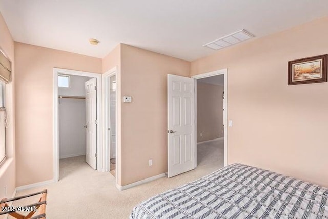 carpeted bedroom with a spacious closet and a closet