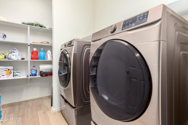 laundry room featuring separate washer and dryer and light hardwood / wood-style flooring