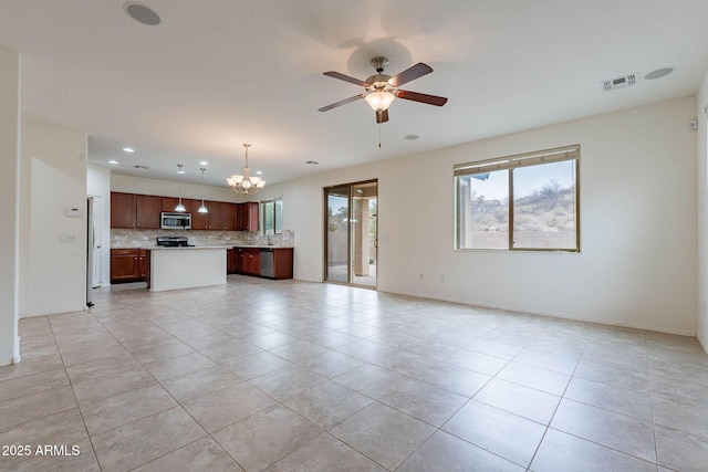 unfurnished living room featuring light tile patterned flooring and ceiling fan with notable chandelier