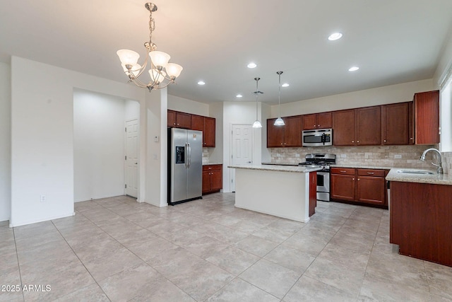 kitchen with sink, appliances with stainless steel finishes, backsplash, a center island, and decorative light fixtures