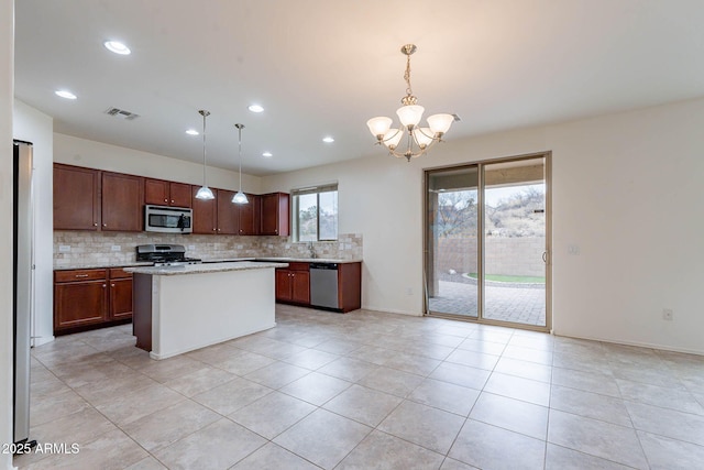 kitchen with stainless steel appliances, pendant lighting, and backsplash