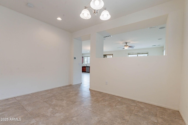 empty room featuring ceiling fan with notable chandelier