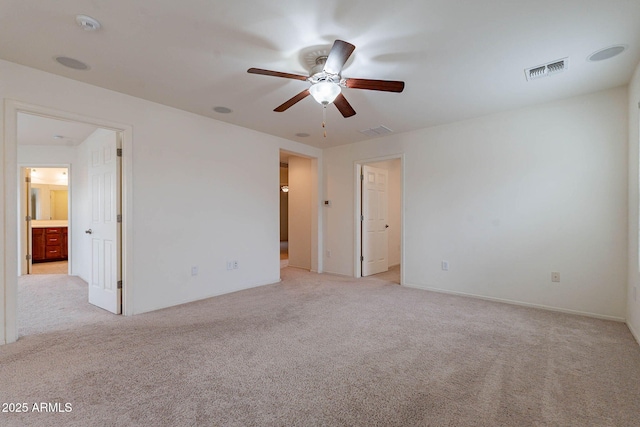 spare room featuring light colored carpet and ceiling fan