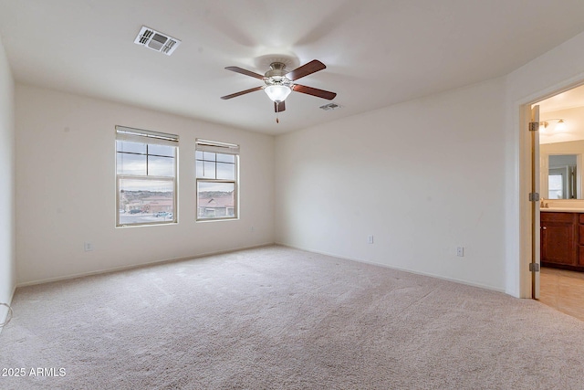 unfurnished room featuring ceiling fan and light carpet