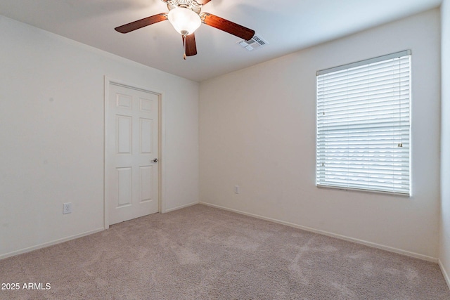 carpeted spare room featuring ceiling fan